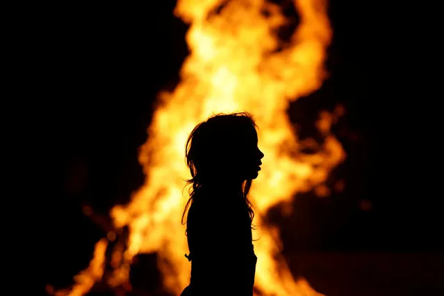 An Ultra-Orthodox Jewish girl stands around a bonfire as she celebrates the Jewish holiday of Lag Ba'Omer in the city of Ashdod, Israel May 13, 2017. (Photo by Amir Cohen/Reuters)