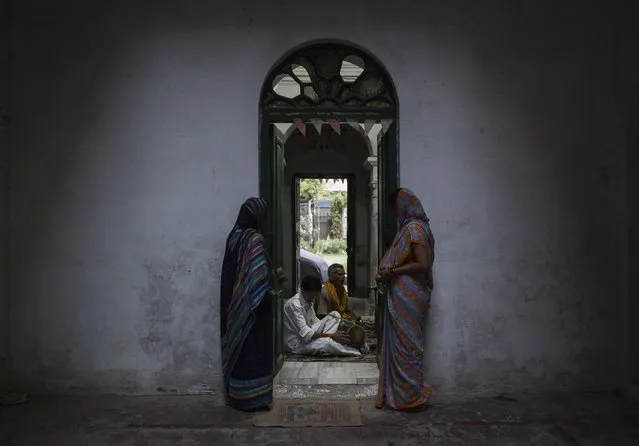 Relatives of patrons listen to priests as they chant during evening prayers at the Mukti Bhavan (Salvation House) in Varanasi, in the northern Indian state of Uttar Pradesh, June 17, 2014. (Photo by Danish Siddiqui/Reuters)