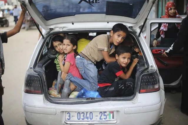 Palestinian children sit in a car boot as they flee their family homes following heavy Israeli shelling during an Israeli ground offensive east of Khan Younis, in the southern Gaza Strip July 23, 2014. Israeli forces pounded multiple sites across the Gaza Strip on Wednesday, including the enclave's sole power plant, and said it was meeting stiff resistance from Hamas Islamists, as diplomats sought to end the bloodshed. (Photo by Ibraheem Abu Mustafa/Reuters)