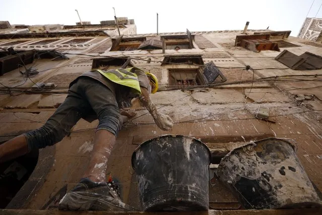 A Yemeni laborer works on the restoration of a UNESCO-listed building in the old city of Sana'a, Yemen, 12 June 2022. Dozens of workers, architects and senior master builders are engaged in urban renovation works since early June 2022 in the old quarter of the Yemeni capital Sana'a, using traditional methods and materials for maintaining its architectural style. The much needed emergency restoration is taking place after unusual torrential rains and a Saudi-led airstrike brought extensive damage to several buildings across the old city over the past few years. The old city of Sana'a was listed as a world heritage site by UNESCO in 1986 as an outstanding expression of Yemen's Arab and Muslim traditional culture. In July 2015, it was inducted to the list of World Heritage in danger due to the damage caused to its cultural heritage. A Saudi-led airstrike targeted an old neighborhood of Sana'a in 2015, destroying completely four historic buildings and killing five people. Three other buildings collapsed, 50 others were severely hit. More than 1,000 buildings have leaky roofs due to heavy rains and associated floods of April and August 2020, according to assessments by the General Organization for the Preservation of Historic Cities in Yemen (GOPHCY). The restoration project, that is funded by the European Union (EU) through UNESCO, is within a 20-million euro agreement signed in March 2022 by the EU and UNESCO for safeguarding Yemen's unique cultural heritage in four provinces across the war-ridden country with its historical richness and cultural and folklore variety. That includes the old city of Sana'a which is a dense warren of centuries-old mud-brick houses. The project focuses on rehabilitation work, urgent interventions and regulatory protection of distinctive multi-story tower buildings. The old city, located in a mountainous valley over 7,200 feet above sea level, was an important center of Islam throughout the 7th and 8th cent. (Photo by Yahya Arhab/EPA/EFE)