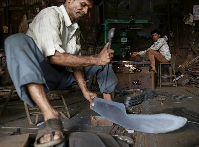 Workers cut and shape metal parts used in heavy machinery inside a workshop at an industrial area i in Mumbai, India, August 12, 2015. India's annual industrial output growth quickened to 3.8 percent in June from a downwardly revised 2.5 percent growth a month ago, government data showed on Wednesday. (Photo by Danish Siddiqui/Reuters)