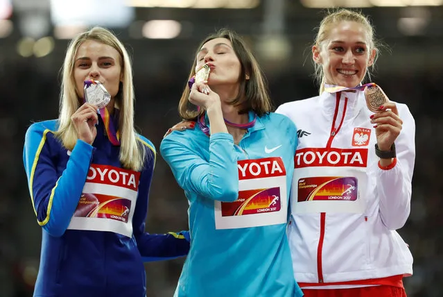 Silver medallist Ukraine' s Yuliia Levchenko (L), gold medallist Authorised Neutral Athlete Maria Lasitskene (C) and bronze medallist Poland' s Kamila Licwinko (R) pose on the podium during the victory ceremony for the women' s high jump athletics event at the 2017 IAAF World Championships at the London Stadium in London on August 12, 2017. (Photo by Matthew Childs/Reuters)