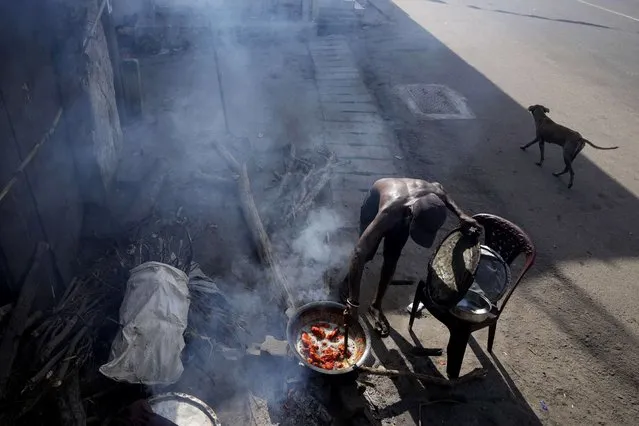 A man cooks food with firewood for his roadside eatery, amid shortage of cooking gas in Colombo, Sri Lanka, Thursday, June 23, 2022. Sri Lanka's prime minister says the island nation's debt-laden economy has “collapsed” as it runs out of money to pay for food and fuel. (Photo by Eranga Jayawardena/AP Photo)