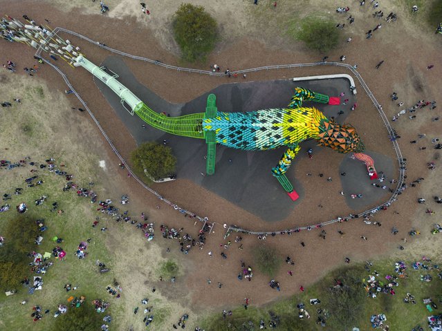 Visitors gather around the newly-inaugurated jungle gym dubbed ,“The Yaguarón”, at Eco Park in San Nicolas, Argentina, Saturday, August 5, 2023. The attraction is based on a regional urban legend of the Yaguaron, a fantastical creature with the head of a dog and the body of a reptile that was said to live in the depths of a nearby stream. (Photo by Rodrigo Abd/AP Photo)