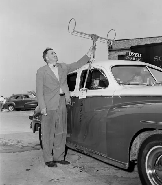 George Fyler, television engineer, adjusts the antenna he designed for the first installation of a television set in a taxicab, shown in Chicago on July 1, 1948. He adapted a standard table model with a four and one-half by six inch viewing screen, which requires only 70 watts of power. The cost of the video set installed is $200. (Photo by Edward Kitch/AP Photo)