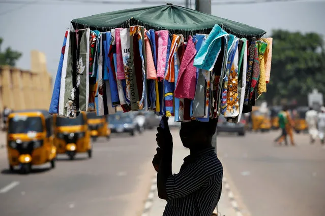 A man selling handkerchiefs walks along a street in Nigeria's northern city of Kano, July 7, 2016. (Photo by Akintunde Akinleye/Reuters)