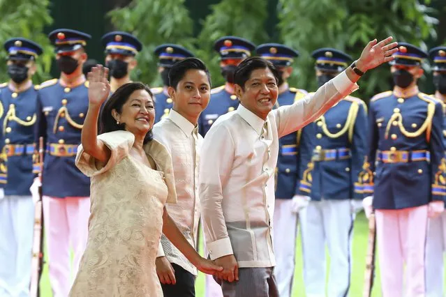Philippine President Ferdinand Marcos Jr., right, waves beside wife Maria Louise, left, and son Sandro as they arrive at Malacanang Presidential Palace after the inauguration ceremony, Thursday, June 30, 2022, in Manila, Philippines. Marcos was sworn in as the country's 17th president. (Photo by Gerard Carreon/AP Photo)