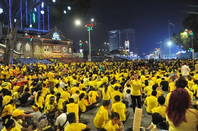 Protesters sit along the main road in downtown Kuala Lumpur during a rally organised by pro-democracy group “Bersih” (Clean), Malaysia, Saturday, August 29, 2015. Tens of thousands of Malaysians wearing yellow T-shirts and blowing horns defiantly held a major rally in the capital Saturday to demand the resignation of embattled Prime Minister Najib Razak. (Photo by AP Photo)