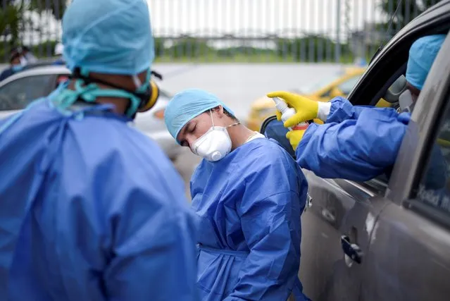 A hospital worker is sprayed with disinfectant at Guasmo Sur General Hospital in Guayaquil, Ecuador on April 1, 2020. (Photo by Vicente Gaibor del Pino/Reuters)