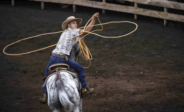 A cowboy participates in a bullfight and ride during the patron saint festivities of the Virgen de los Angeles, in the town of Angeles de Santo Domingo, province of Heredia, Costa Rica, 14 August 2022 (issued 16 August 2022). (Photo by Jeffrey Arguedas/EPA/EFE)