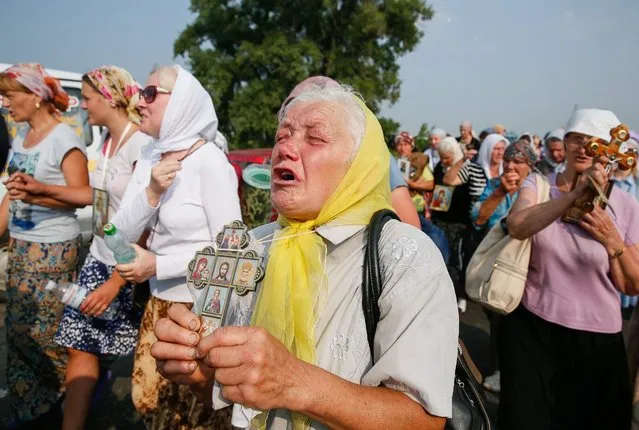 Ukrainian believers from the Ukrainian Orthodox Church of Moscow Patriarchate march near the town of Boryspil, Kiev region, Ukraine, 25 July 2016. Ukrainian activists gathered on 25 July at the entry to the town of Boryspil in Kiev region to prevent those participating in the religious march of the Ukrainian Orthodox Church of the Moscow Patriarchate from entering the city of Kiev. The activists were holding Ukraine's national flag and the red and black banners of the Organization of Ukrainian Nationalists (OUN), as local media reported. (Photo by Roman Pilipey/EPA)