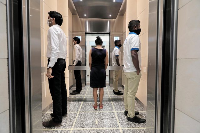 People practice social distancing inside an elevator prior to arriving to their work places at World Trade Center, after the government announced that private and state companies will reopen their offices after almost two months of lockdown amidst concerns about the spread of coronavirus disease (COVID-19) in Colombo, Sri Lanka on May 11, 2020. (Photo by Dinuka Liyanawatte/Reuters)