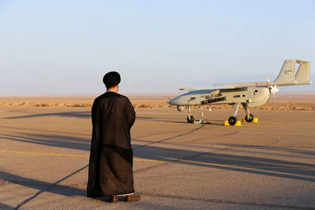 An Iranian cleric stands near a drone during a military exercise in an undisclosed location in Iran, in this handout image obtained on August 24, 2022. (Photo by Iranian Army/WANA (West Asia News Agency)/Handout via Rtuters)
