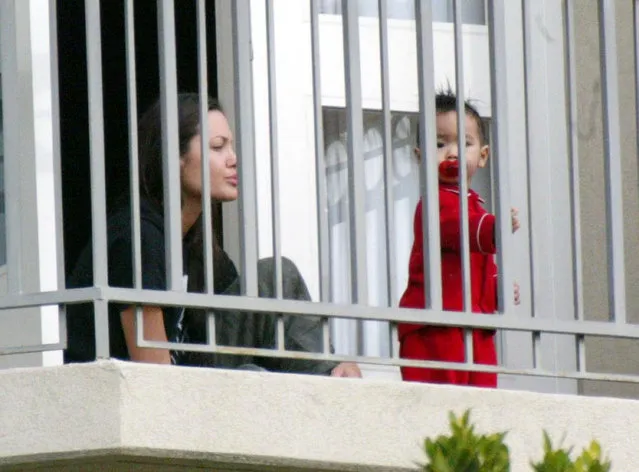 Actress Angelina Jolie plays with her son, Maddox, on the balcony of a hotel on December 30, 2002 in Beverly  Hills, California. (Photo by Frazer Harrison)