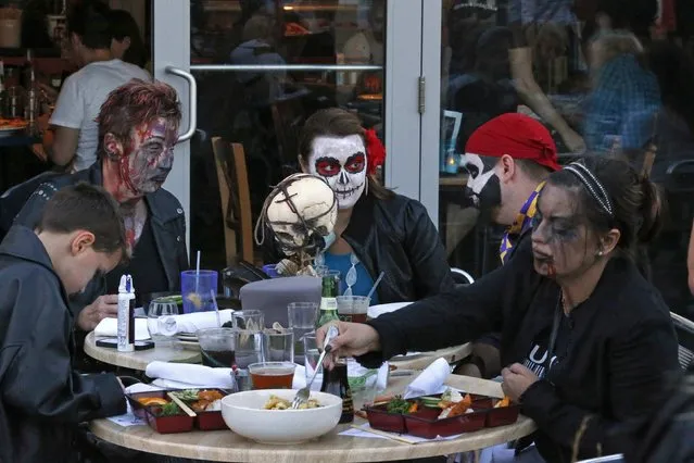 Revellers have lunch during a Zombie Walk in Asbury Park, New Jersey October 4, 2014. (Photo by Eduardo Munoz/Reuters)