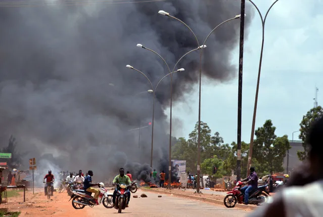 Residents burn tires along a street in Ouagadougou on September 17, 2015, after Burkina Faso's presidential guard declared a coup, a day after seizing the interim president and senior government members, as the country geared up for its first elections since the overthrow of longtime leader Blaise Compaore. AFP PHOTO / AHMED OUOBA