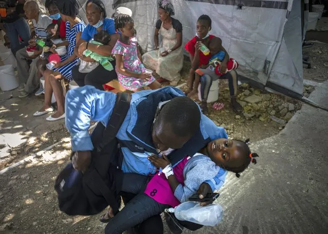 A girl suffering from cholera symptoms is helped by her father upon arrival at a clinic run by Doctors Without Borders in Port-au-Prince, Haiti, Thursday, October 27, 2022. For the first time in three years, people in Haiti have been dying of cholera, raising concerns about a potentially fast-spreading scenario and reviving memories of an epidemic that killed nearly 10,000 people a decade ago. (Photo by Ramon Espinosa/AP Photo)