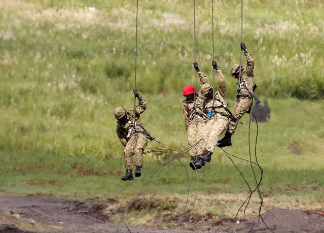 Japanese Ground Self-Defense Force soldiers descend from a helicopter with ropes during an annual training session near Mount Fuji at Higashifuji training field in Gotemba, west of Tokyo, August 25, 2016. (Photo by Kim Kyung-Hoon/Reuters)