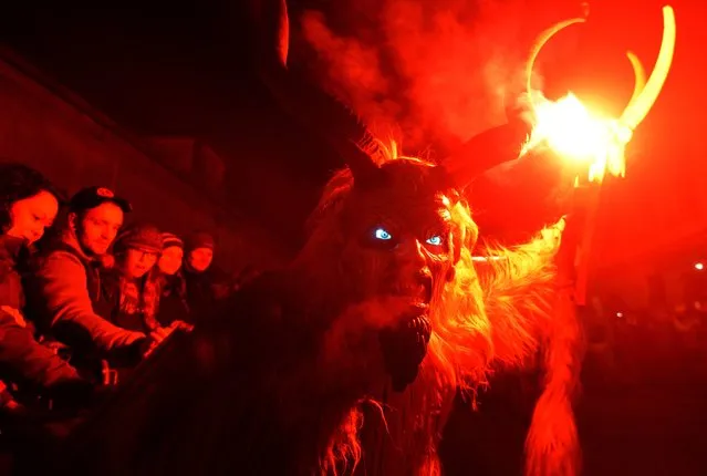 Actors dressed as “Krampus” figures present a show of a traditional custom in Kaplice, South Bohemia, on December 12, 2015. (Photo by Michal Cizek/AFP Photo)