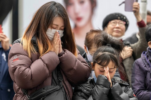 People pray as they take part in a minute of silence to remember the victims on the 14th anniversary of the 2011 earthquake, tsunami and nuclear disaster, in the Ginza shopping district of Tokyo on March 11, 2025. (Photo by Yuichi Yamazaki/AFP Photo)