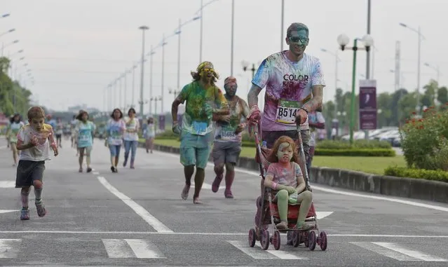 Participants are covered by colored powder as they compete in The Color Run, a five-kilometre untimed race, in Hanoi, Vietnam September 26, 2015. Approximately 7,000 participants took part in Hanoi's first Color Run, reported local media. (Photo by Reuters/Kham)