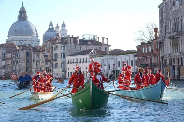 People wearing Santa Claus costumes row on Canal Grande in Venice, Italy, Sunday, December 17 2017. Almost a hundred traditional rowing boats, of various kinds and sizes, for about two hundred rowers, gave life to the traditional water procession of the Santa Claus, parading along the Grand Canal. (Photo by Andrea Merola/ANSA via AP Photo)