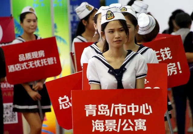 Promotional staff hold banners advertising a new apartment at a property expo in Beijing, China, September 18, 2015. Home prices in China rose for a fourth consecutive month in August, offering hope that the ailing property sector is becoming less of a drag on the slowing economy. (Photo by Kim Kyung-Hoon/Reuters)