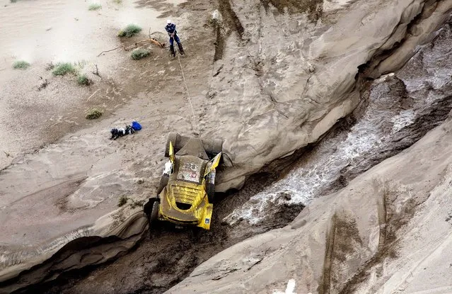 Pascal Larroque uses a cable to pull his car from the bank of a river during the 11th stage of the 2013 Dakar Rally from La Rioja to Fiambala, Argentina, January 16, 2013. (Photo by Bertrand Metayer/Le Parisien)