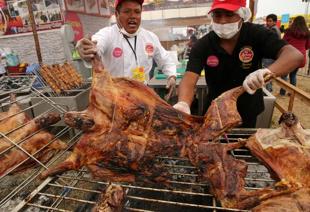 Cooks grill lambs over wood fire during Mistura gastronomic fair, which promotes Peruvian cuisine by showcasing food and products from all over the country, in Lima, Peru, September 8, 2016. (Photo by Mariana Bazo/Reuters)