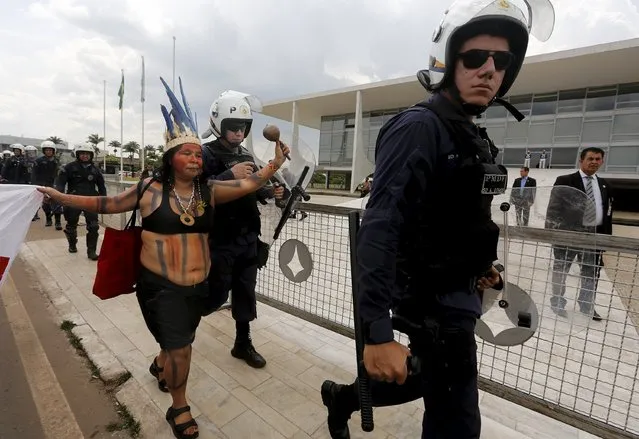A Gamela indigenous leader walks next to police officers during a demonstration to discuss issues of land demarcation and indigenous rights with authorities in front of the Planalto Palace in Brasilia, Brazil, October 7, 2015. (Photo by Lunae Parracho/Reuters)