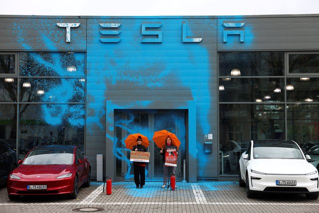 Supporters of New Generation (Neue Generation) demonstrate after they spray painted the facade of a Tesla dealership to protest against Elon Musk and against what organizers say is the destruction of democracy and the climate by the rich, in Berlin, Germany on March 31, 2025. (Photo by Christian Mang/Reuters)