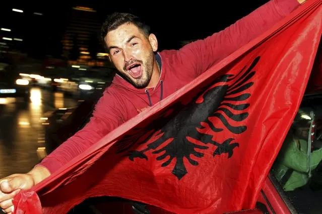 An Albanian soccer fan celebrates after Albania beat Armenia in their Euro 2016 Group I qualifying soccer match, in Tirana, Albania October 11, 2015. Albania qualified for Euro 2016, their first ever major tournament, when a 3-0 away win over Armenia clinched second place in Group I above Denmark on Sunday sparking wild celebrations across the country. (Photo by Arben Celi/Reuters)