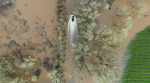 A vehicle drives on a flooded road in Sebastopol, California, on January 05, 2023. Excessive rain, heavy snow and landslides are expected to wallop California through Thursday as a series of winter storms rip across the western US coast, prompting Governor Gavin Newsom to declare a state of emergency. (Photo by Josh Edelson/AFP Photo)