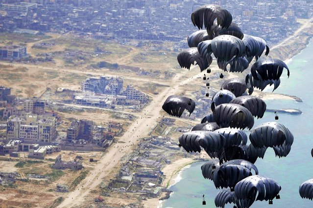 Containers of humanitarian aid is airdropped to Palestinians in the Gaza Strip from a U.S. C-17 Air Force plane, Friday, March 29, 2024. (Photo by Hussein Malla/AP Photo)