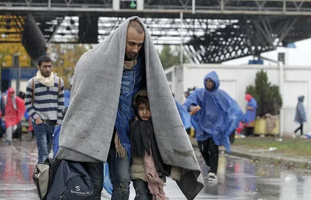 Migrants cover themselves with a blanket as they walk into Slovenia from Trnovec, Croatia, October 19, 2015. (Photo by Srdjan Zivulovic/Reuters)