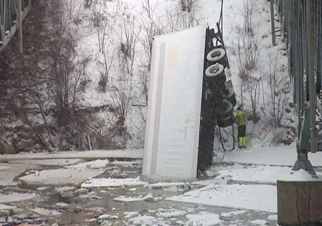 This frame grab provided by WEAU-TV shows a semi that authorities say slipped off a snow-covered road and plunged into the Red Cedar River Tuesday, March 5, 2013 near Menomonie, Wis. Police says a body believed to be the driver has been recovered from the river and emergency crews are  searching for a second person. (Photo by AP Photo/Courtesy WEAU-TV)