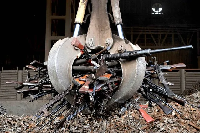 A crane carry part of 9,517 weapons seized from the FARC and ELN guerrillas criminal gangs and organized crime, before being melted in furnaces of the National Steel Factory (Sidenal), on November 25, 2014 in Sogamoso, Boyaca department, Colombia. The metal (iron and steel), obtained from these weapons will be used in the manufacture of rods used to reinforce the foundations and columns of schools and hospitals in areas of armed conflict. (Photo by Guillermo Legaria/AFP Photo)