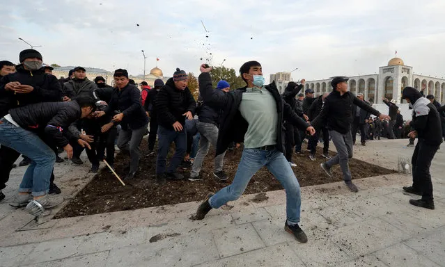 Supporters of nationalist Sadyr Japarov, who has styled himself as prime minister throw clumps of earth towards supporters of former Kyrgyzstan's President Almazbek Atambayev as they attend a rally in Bishkek on October 9, 2020. Two large crowds supporting rival politicians clashed in Kyrgyzstan's capital Bishkek as a power vacuum persisted and President Sooronbay Jeenbekov said he was ready to resign. (Photo by Vyacheslav Oseledko/AFP Photo)
