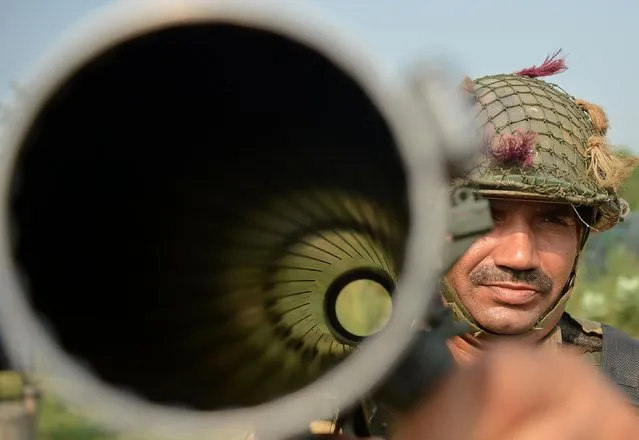 An Indian Border Security Force (BSF) soldier carries a rocket launcher as he takes up position with colleagues at an outpost along a fence at the India-Pakistan border in R.S Pora south-west of Jammu on October 2, 2016. India has evacuated thousands of people near the Pakistani border in Punjab state following the military raids on militant posts, which provoked furious charges of “naked aggression” from Pakistan. The move followed a deadly assault on one of India's army bases in Kashmir that New Delhi blamed on Pakistan-based militants, triggering a public outcry and demands for military action. (Photo by Tauseef Mustafa/AFP Photo)