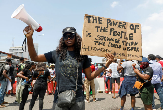 A demonstrator holds a banner during a protest against alleged police brutality, in Lagos, Nigeria on October 12, 2020. (Photo by Temilade Adelaja/Reuters)