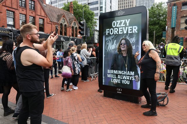 A woman poses for a picture next to an image of Ozzy Osbourne, as people pay tribute to the former Black Sabbath frontman, in Birmingham, Birmingham, Britain, on July 30, 2025. (Photo by Jack Taylor/Reuters)