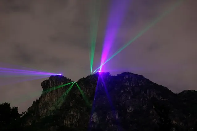 Pro-democracy activists light up the iconic Lion Rock to urge the release of twelve Hong Kong activists detained on the Chinese mainland, who were arrested at sea after attempting to flee to Taiwan, in Hong Kong, China on October 12, 2020. (Photo by Tyrone Siu/Reuters)