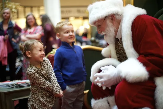 Brayden Knowles, 2, greets Santa Claus, with brother Brynlie, 4, at The Plaza, King of Prussia Mall, United State's largest retail shopping space, in King of Prussia, Pennsylvania on December 6, 2014. The 2.7 million square feet shopping destination is owned by Simon Property Group. Picture taken December 6, 2014. (Photo by Mark Makela/Reuters)