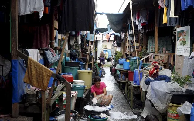 A housewife does laundry outside her bunkhouse at a transitional shelter for Typhoon Haiyan survivors in Tacloban city November 1, 2015, ahead of the second anniversary of the devastating typhoon that killed more than 6000 people in central Philippines. (Photo by Erik De Castro/Reuters)