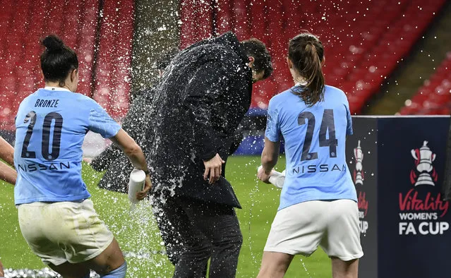 Manchester City's Lucy Bronze, left, and Keira Walsh, right, celebrate with Manchester City's manager Gareth Taylor, center, after winning the Women's FA Cup final soccer match between Everton and Manchester City at Wembley stadium in London, Sunday, November 1, 2020. (Photo by Facundo Arrizabalaga/Pool via AP Photo)