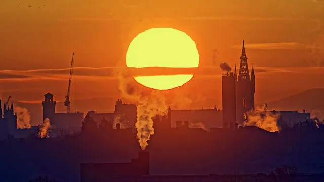 Cold Red Dawn saw sunrise over the west end and the Gothic tower of Glasgow university, Scotland as the water vapour and smoke solidified in the cold air on January 27, 2023. (Photo by Gerard Ferry/Alamy Live News)
