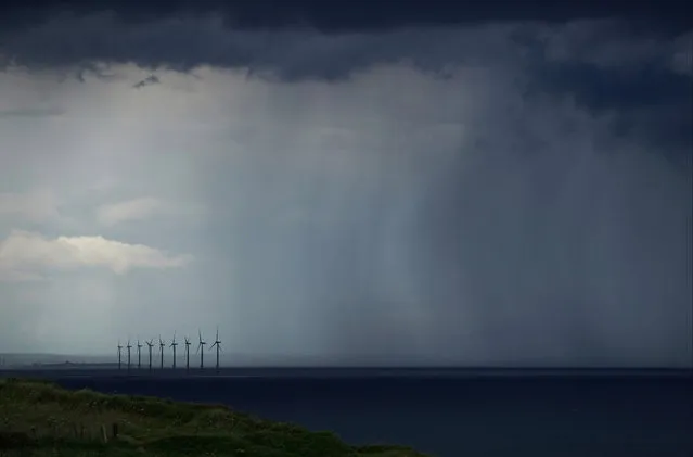 Rain falls near an offshore windfarm as a thunderstorm approaches overhead on June 27, 2020 in Saltburn By The Sea, England. Thunderstorms have passed over some of the country today following high temperatures through the week. (Photo by Ian Forsyth/Getty Images)
