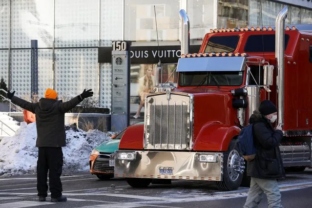 A counter-protester tries to block truckers and supporters' protest against coronavirus disease (COVID-19) vaccine mandates, in Toronto, Ontario, Canada, February 5, 2022. (Photo by Chris Helgren/Reuters)