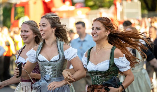 Visitors storm onto the festival meadow for the start of Oktoberfest, on Munich's Theresienwiese, in Germany, Saturday, September 20, 2025. (Photo by Leonie Asendorpf/dpa via AP Photo)
