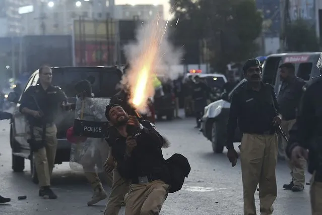 Police fire tear gas shells towards Pakistan Tehreek-e-Insaf (PTI) party activists and supporters of former Pakistan's Prime Minister Imran during a protest against the arrest of their leader, in Karachi on May 9, 2023. Police fired water cannon and tear gas on May 9 to quell protests that erupted in several cities across Pakistan, hours after former prime minister Imran Khan was arrested in connection with a graft case. (Photo by Asif Hassan/AFP Photo)